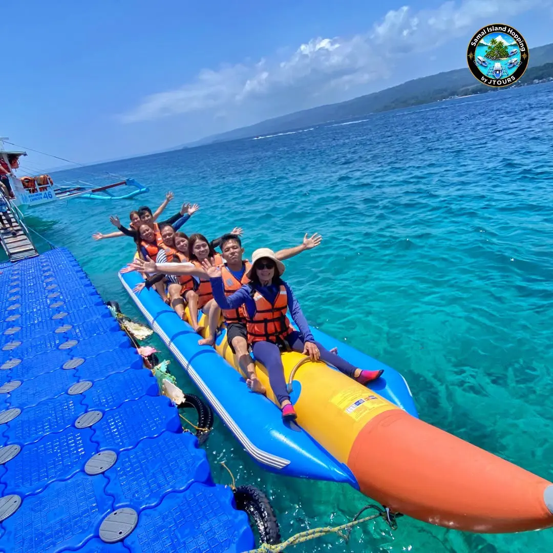 Guests riding a yellow banana boat towed from a floating pontoon